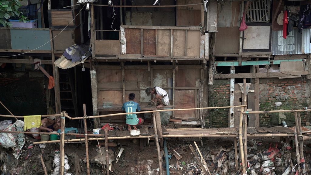 Aktivitas warga di bantaran Sungai Ciliwung di Bidara Cina, Jatinegara, Jakarta Timur, Rabu (17/2/2021). Badan Pusat Statistik merilis jumlah penduduk miskin di Jakarta kini 4,69 persen dari total penduduknya atau 496.840 jiwa, hampir mencapai 497.000 jiwa. Dalam enam bulan pertama pandemi, ada tambahan 16.000 warga miskin di Ibu Kota. Kemiskinan bertambah antara lain karena angka pengangguran naik dan mata pencarian pekerja terdampak pandemi.