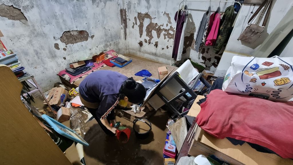 Warga mengambil barang-barang dari salah satu ruangan rumahnya yang terendam banjir dari luapan Sungai Cikapundung di RW 004 Kelurahan Braga, Kecamatan Sumur Bandung, Kota Bandung, Jawa Barat, Kamis (11/1/2024).