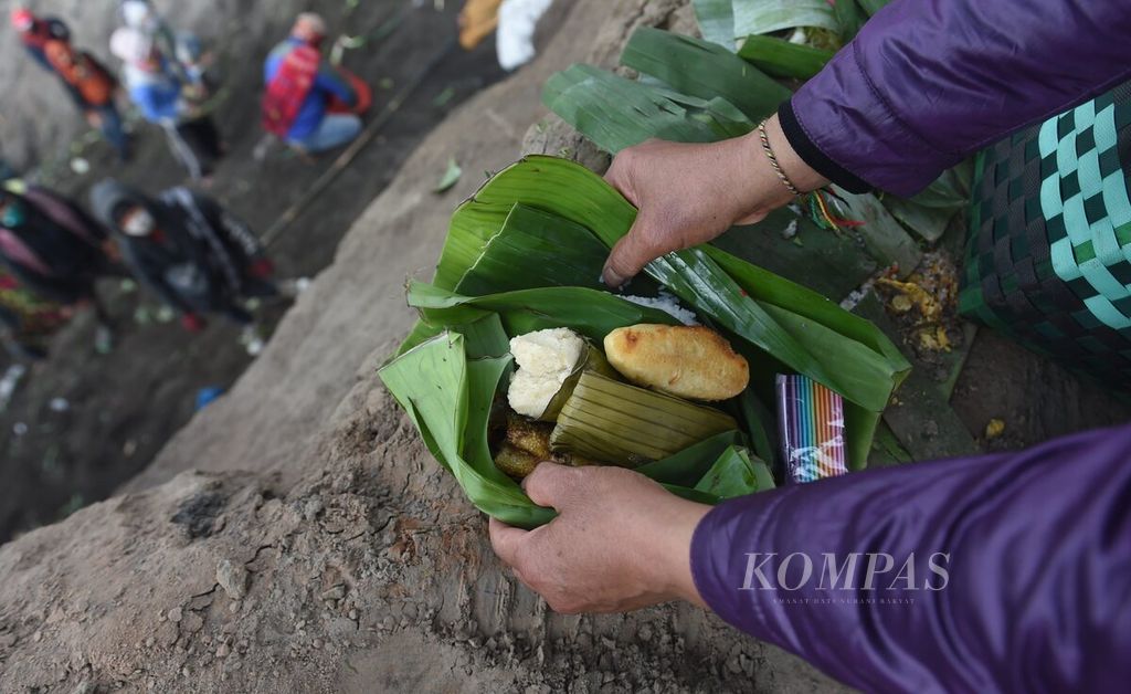 Warga Tengger meletakkan sesaji berupa kue di Kawah Gunung Bromo saat pelaksanaan Yadnya Kasada di Desa Ngadisari, Kecamatan Sukapura, Kabupaten Probolinggo, Jawa Timur, Kamis (16/6/2022). 