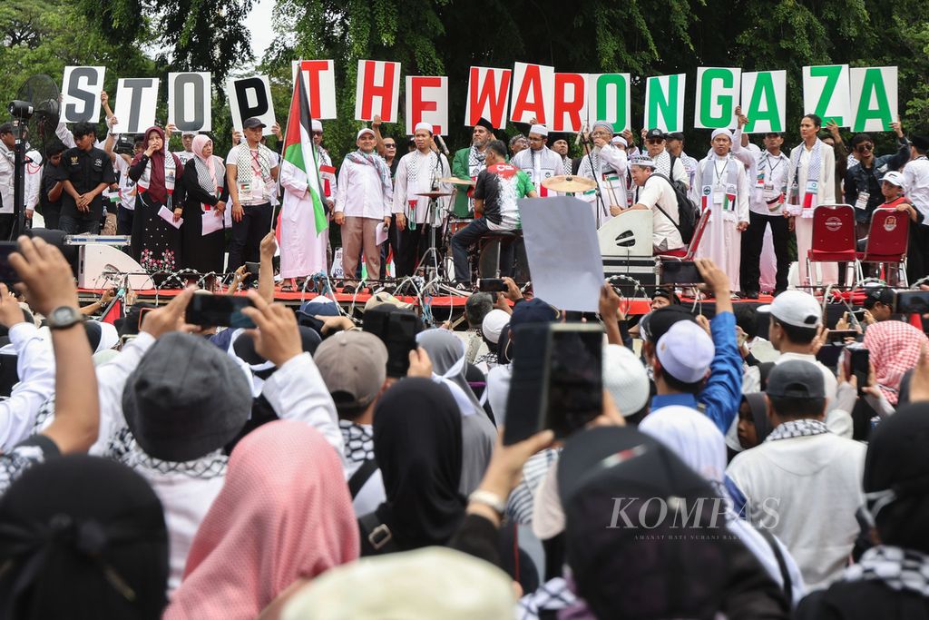 Peserta aksi mengangkat poster bertuliskan "Stop The War On Gaza" di depan Kedutaan Besar Amerika Serikat, Jakarta, Sabtu (13/1/2024). 