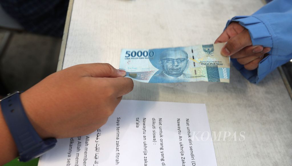 Murid-murid SDIT Ibnu Sina, Duren Sawit, Jakarta Timur mengikuti praktek membayar zakat fitrah setara 3,5 liter beras atau uang senilai Rp 40.000 di sekolah tersebut, Kamis (30/3/2023). 