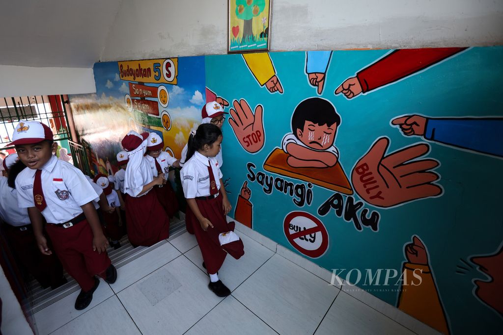 Students walk in front of an anti-bullying mural at SDN Kalibata 11, Jakarta, Monday (22/4/2024).