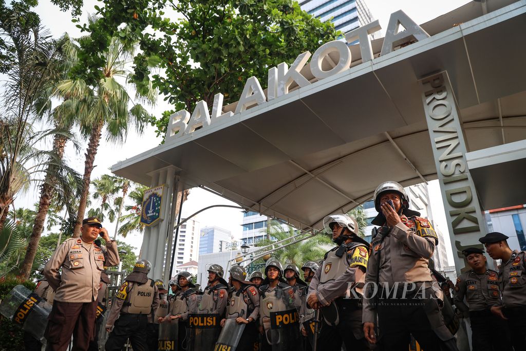 Polisi berjaga di depan gerbang Balai Kota Jakarta, Selasa (21/11/2023). Buruh menuntut kenaikan upah yang berkeadilan setelah Pemerintah Provinsi DKI Jakarta mengusulkan kenaikan UMP 2024 sebesar Rp 165.583 menjadi Rp 5.067.381. 