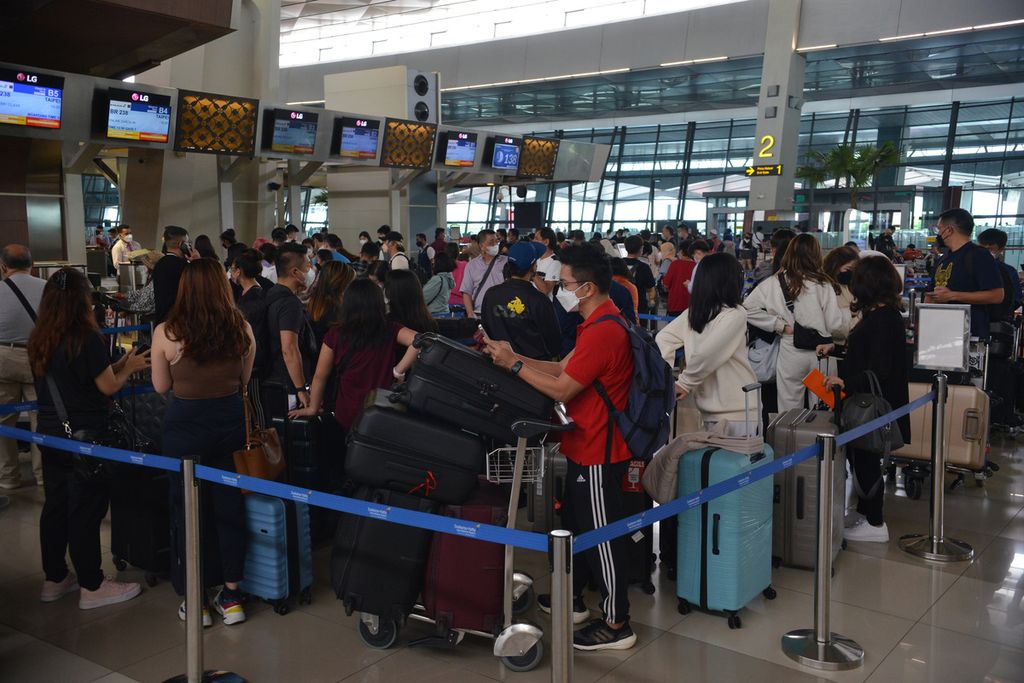 Calon penumpang pesawat mengantre di loket pelaporan keberangkatan di Terminal 3 Bandara Internasional Soekarno-Hatta, Tangerang, Banten, Selasa (20/12/2022). 