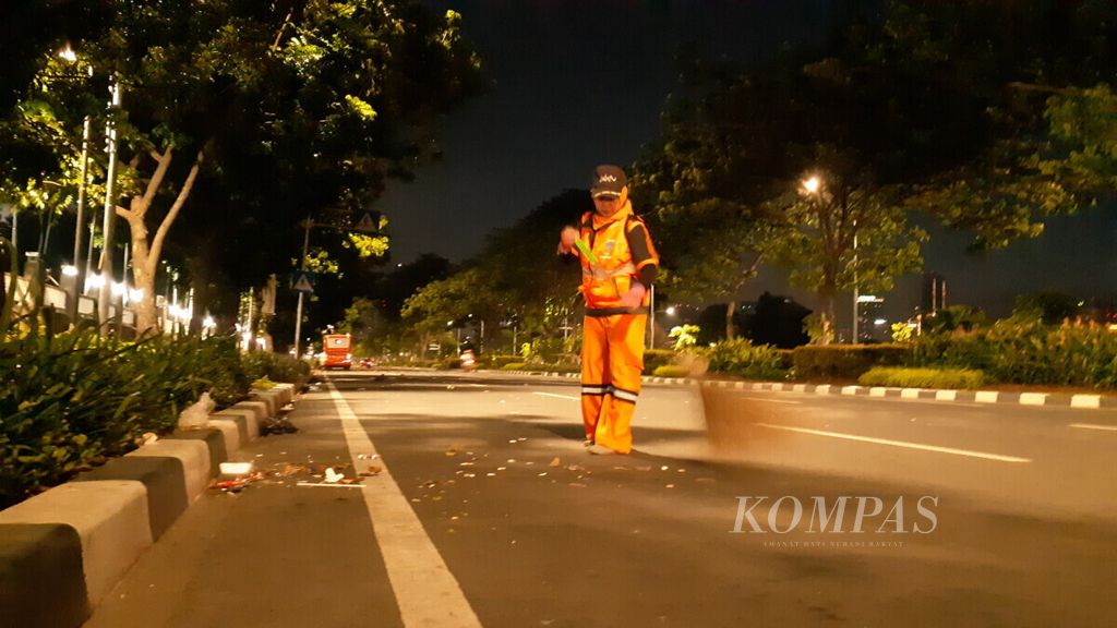 Sumianah (38), tinggal di Kebayoran Baru, Jakarta, sudah bekerja sebagai pasukan oranye sejak 2015 sedang membersihkan sampah di depan kantor RRI hingga Halte Taman Ria, Sabtu (5/1/2019) subuh.
