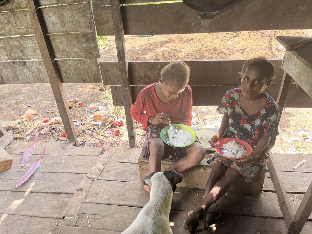 Anak-anak Dorce Gebze (30) di Kampung Zanegi, Distrik Animha, Kabupaten Merauke, Papua, tengah memakan nasi tanpa lauk-pauk atau biasa mereka sebut nasi kosong, Kamis (10/11/2022).