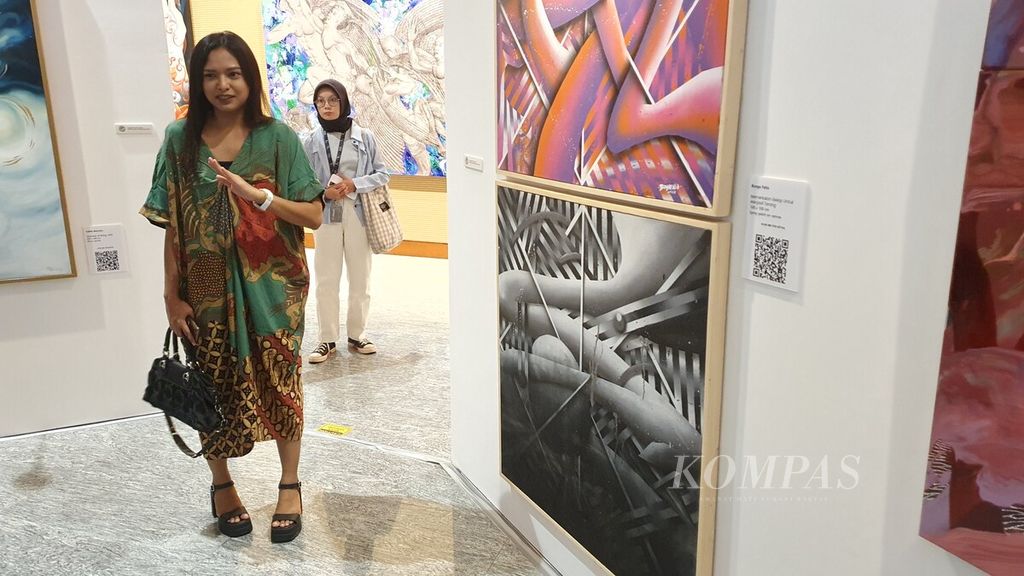 Pelukis Bunga Fatia menjelaskan karya seninya yang berjudul "Memerlukan Gelap untuk Menjadi Terang" yang dipamerkan dalam pameran seni rupa Indonesian Dream di Galeri Astra, Jakarta, 3-6 November 2023.