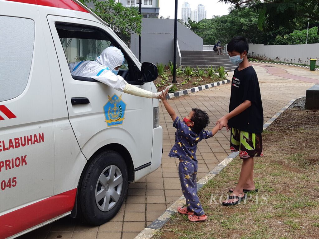 Anak balita penderita Covid-19 yang tengah menjalani isolasi mandiri di Menara 9 Wisma Atlet Pademangan, Jakarta Utara, menyapa pengemudi ambulans, Sabtu (30/1/2021).