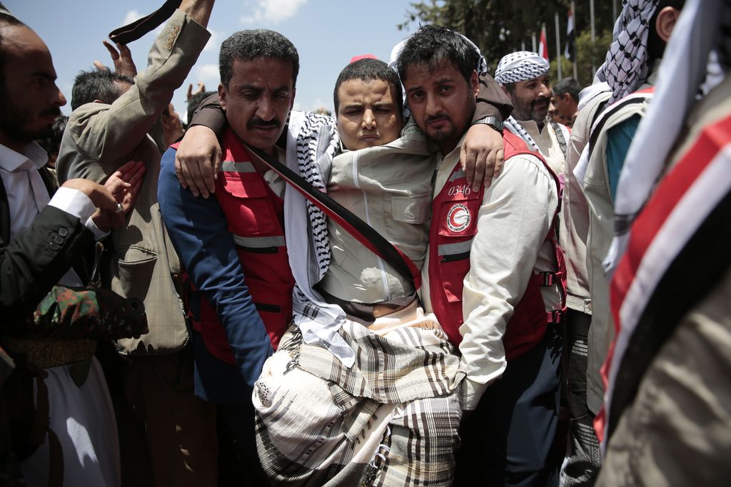  Tim paramedis membawa anggota tahanan dari kelompok media dalam pertukaran tahanan perang antara mereka dan Pemerintah Yaman di Bandar Udara Sana'a, Jumat (14/4/2023).  