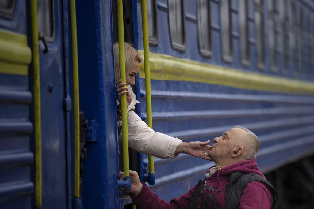  Seorang perempuan menyampaikan ucapan perpisahan kepada seorang lelaki di dekat pintu kereta yang akan berangkat menuju Lviv dari Kiev, Ukraina, Kamis (3/3/2022). Anggota keluarga laki-laki berusia dewasa memilih bertahan di Ukraina untuk membantu militer mempertahankan negaranya dari serbuan Rusia. 