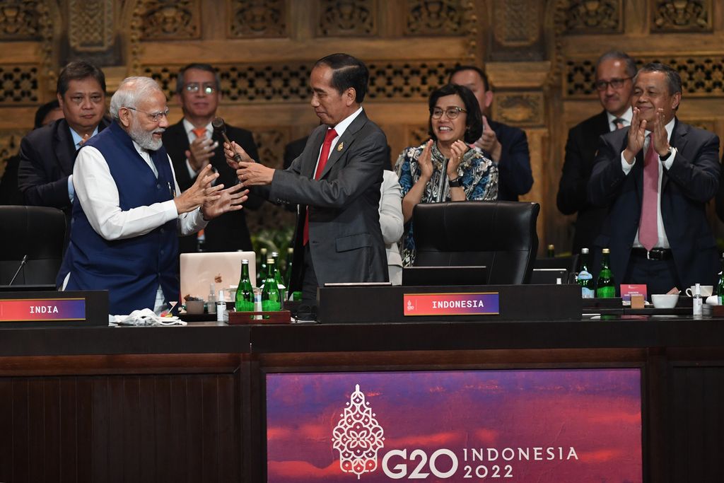 Presiden Joko Widodo (tengah) menyerahkan presidensi G20 ke Perdana Menteri India Narendra Modi (kiri)  pada penutupan Sesi Kerja 3 Konferensi Tingkat Tinggi G20 di Nusa Dua, Bali, Rabu (16/11/2022). 