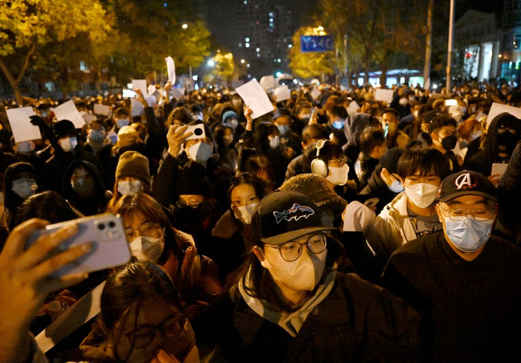 Pengunjuk rasa berjalan di sepanjang jalan saat demonstrasi menentang aturan ketat terkait kebijakan nihil Covid-19 di Beijing, China, 28 November 2022. 