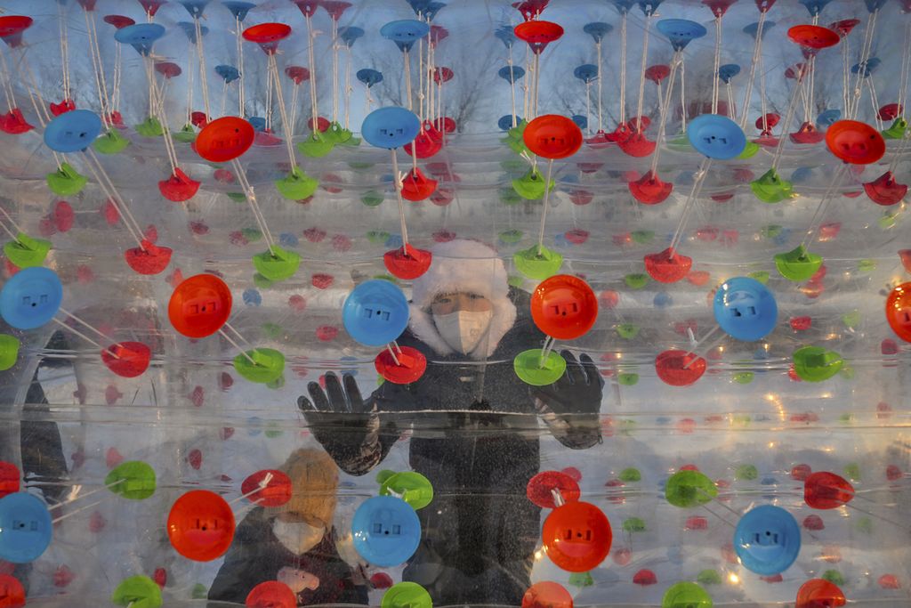 Seorang anak laki-laki berjalan di dalam bola plastik di sebuah taman hiburan di Harbin, di provinsi Heilongjiang timur laut China, menjelang Festival Es dan Salju Internasional Harbin China ke-39, Rabu (4/1/2023). 