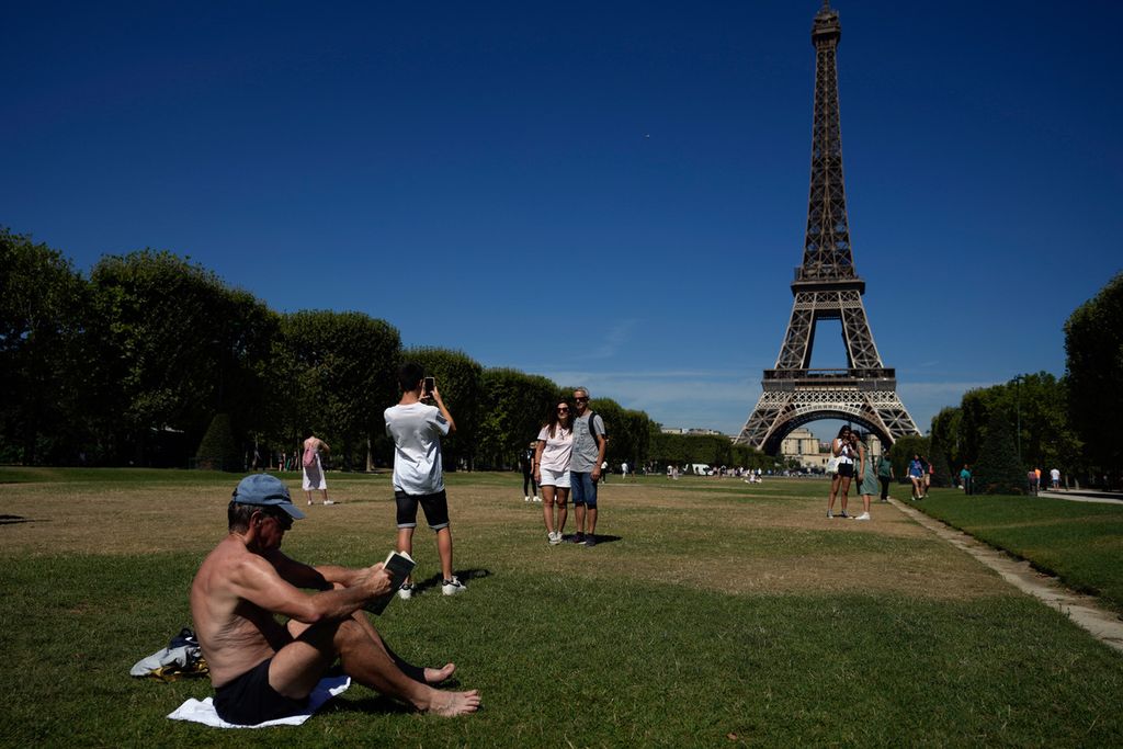 Seorang wisatawan sedang berjemur, Rabu (3/8/2022), di Paris, Perancis. Gelombang panas tengah melanda Kawasan Eropa. Di Paris sendiri, suhu udara mencapai 36 derajat celsius atau sekitar 97 fahrenheit. 