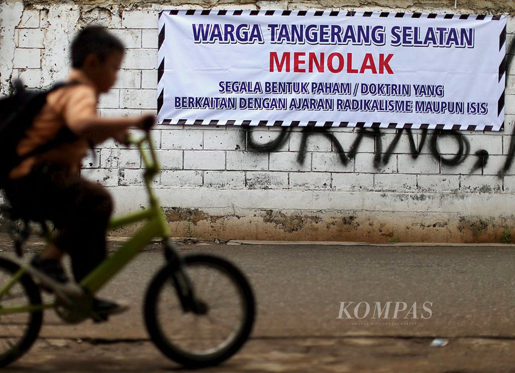 Siswa melintas di depan spanduk menolak radikalisme yang terpampang di Kawasan Jurang Mangu, Tangerang Selatan, Banten, Sabtu (23/1/2016). 
