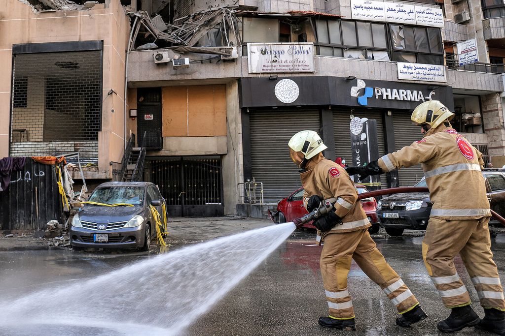 A member of Lebanon's Civil Defense sprayed water onto the street near a building that was hit by an Israeli attack targeting Hamas Deputy Leader Saleh al-Arouri in the southern suburbs of Beirut, Lebanon on Wednesday (3/1/2024).
