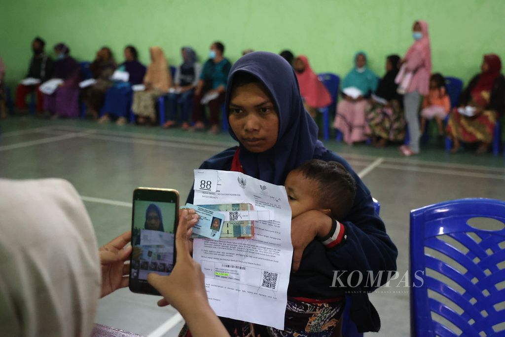 Petugas pengawas memotret warga penerima bantuan uang tunai di Balai Desa Kaponan, Kecamatan Pakis, Magelang, Jawa Tengah (28/11/2022). 