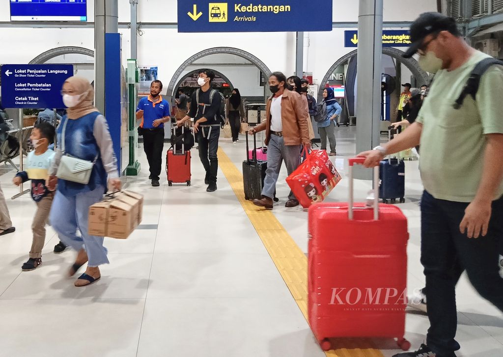 Seorang <i>porter</i> mendekatinya dan menawarkan jasa angkut barang kepada penumpang yang baru saja tiba di Stasiun Pasar Senen, Kamis (9/3/2023).