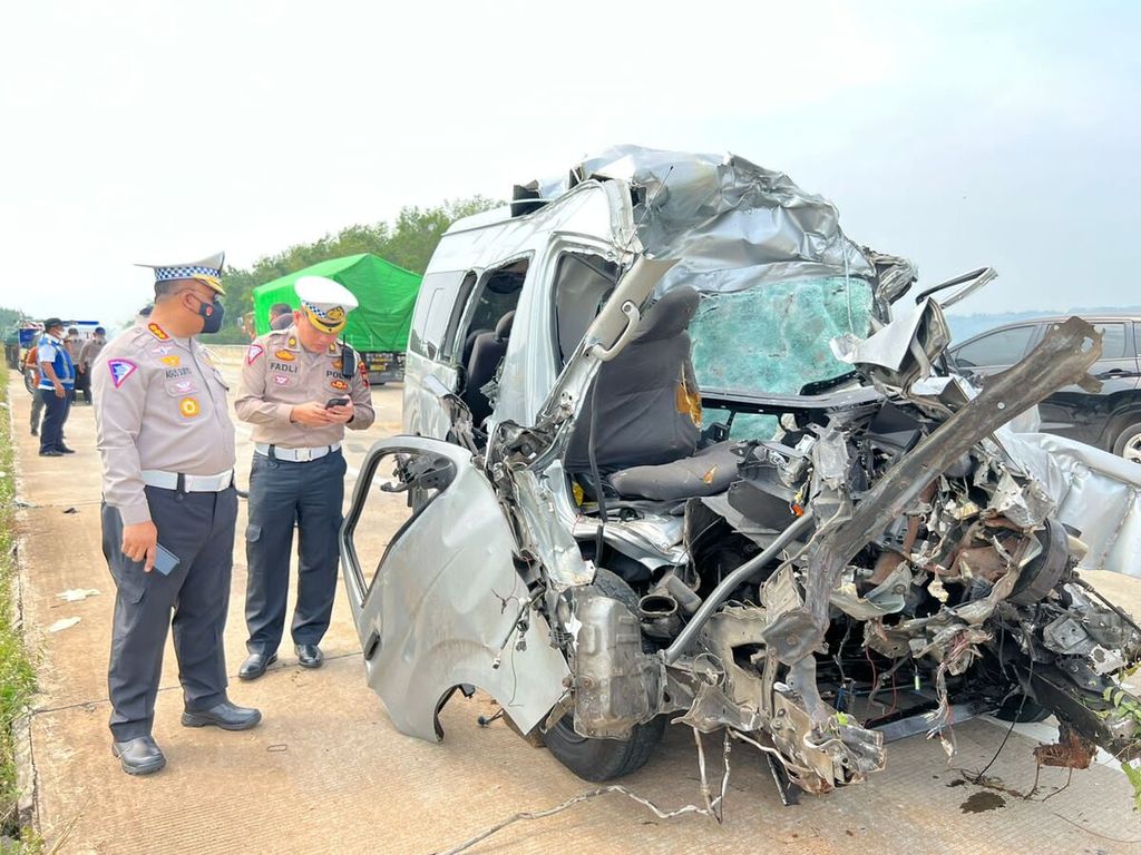 Petugas kepolisian mengecek kondisi mobil yang terlibat dalam kecelakaan tabrak belakang di Jalan Tol Semarang-Batang, Jawa Tengah, Senin (5/9/2022). Dalam kecelakaan tersebut, tujuh orang meninggal dunia dan enam orang luka-luka.