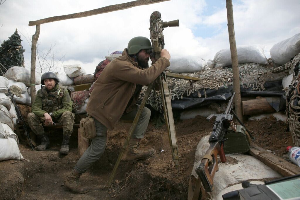 Tentara Ukraina melihat melalui periskop di posisinya di garis depan perbatasan dengan Rusia, tak jauh dari Donetsk, 22 April 2021.