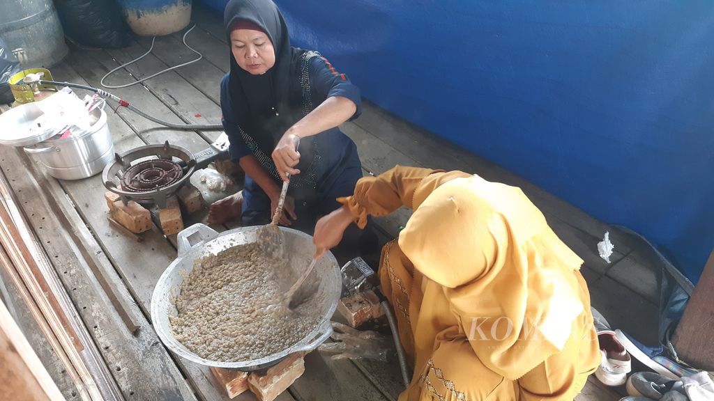 Dua perempuan di Desa Simpang Tiga Abadi, Kecamatan Tulung Selapan, Kabupaten Ogan Komering Ilir, Sumatera Selatan, sedang mengolah bandeng untuk dijadikan abon, Kamis (17/11/2022). Abon menjadi salah satu produk yang diajarkan kepada para wanita di pesisir untuk meningkatkan kapasitas masing-masing.