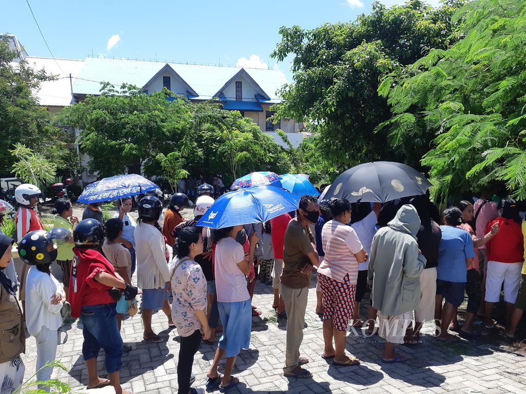 Di bawah terik matahari, warga mengantre untuk mendapatkan kupon pembelian beras murah dalam kegiatan operasi pasar yang digelar Perum Bulog di Kota Kupang, Nusa Tenggara Timur, pada Senin (13/3/2023). 