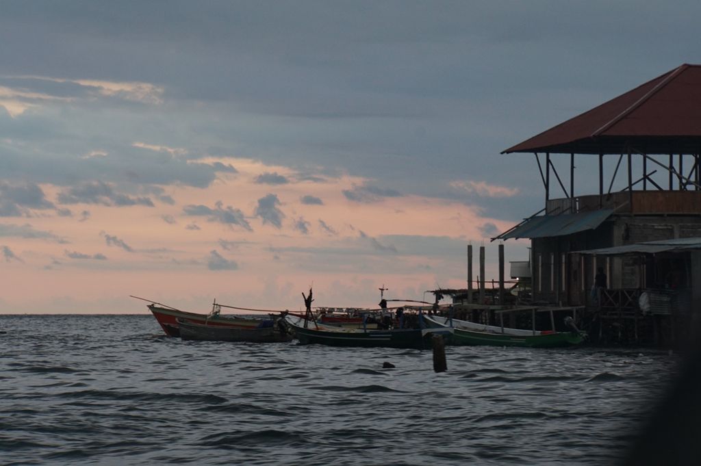 Suasana senja di Desa Tumbak di Pusomaen, Minahasa Tenggara, Sulawesi Utara, pada Minggu (24/11/2019). Desa yang didirikan suku Bajo, pelaut nomaden, ini masih mempertahankan rumah-rumah kayu di atas perairan.