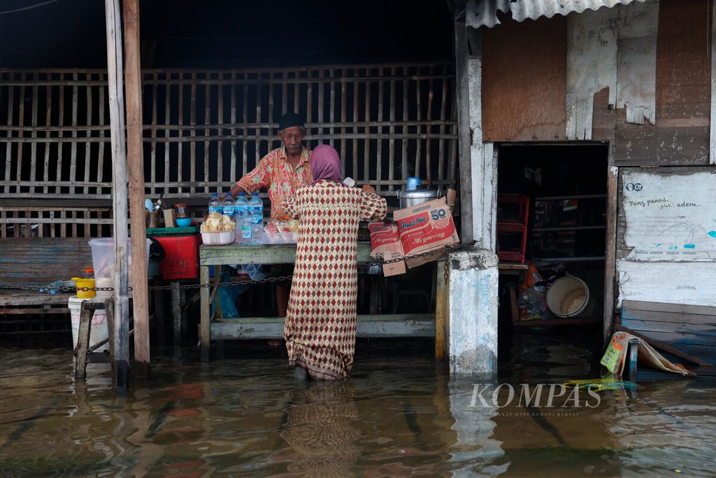 Warga kembali membuka dagangannya di tengah banjir yang masih menggenangi kawasan Kaligawe, Kota Semarang, Jawa Tengah, Senin (2/1/2023). 