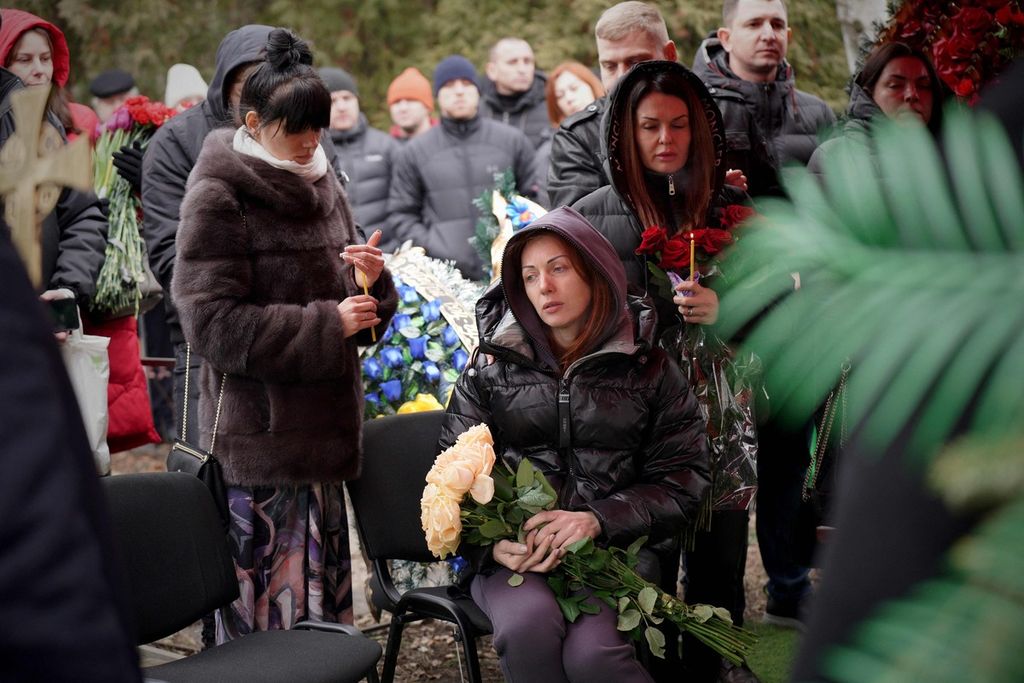 Keluarga dan kerabat tampak berduka saat berlangsung pemakaman Mykhaylo Korenovsky, pelatih tinju Ukraina, yang tewas dalam serangan di gedung permukiman di Dnipro, Ukraina, Selasa (17/1/2023). 