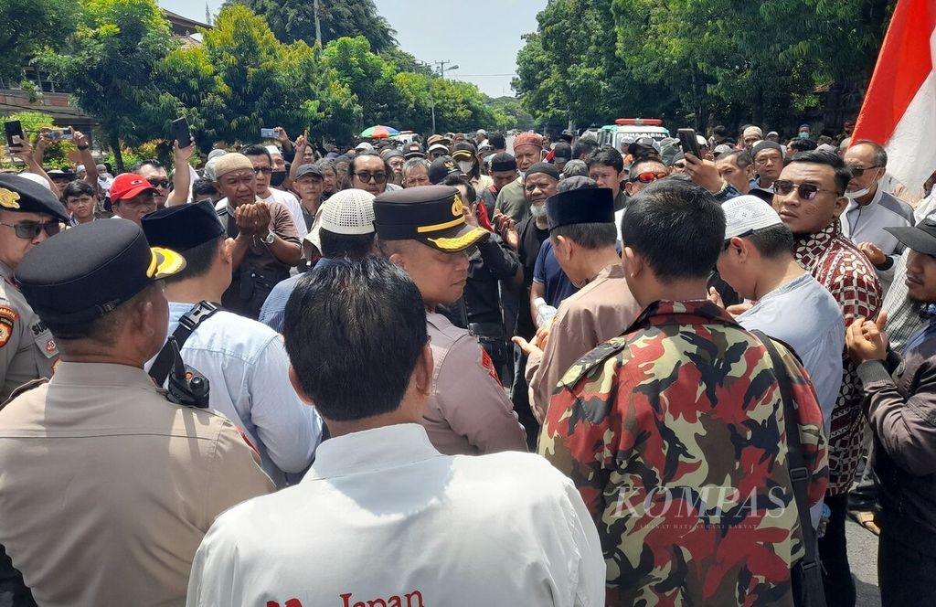 Polisi mengawal unjuk rasa Forum Peduli Keberagaman Bali di seberang Kantor DPD Perwakilan Provinsi Bali di Kota Denpasar, Kamis (4/1/2024). 