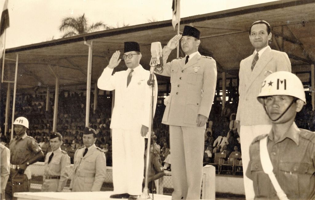 Presiden Sukarno (tengah) dan Wakil Presiden Mohammad Hatta (kiri) membuka Pekan Olahraga Angkatan Perang di Stadion Ikada Jakarta, September 1952. Hadir di panggung kehormatan, Menteri Pertahanan Hamengku Buwono IX (kanan).