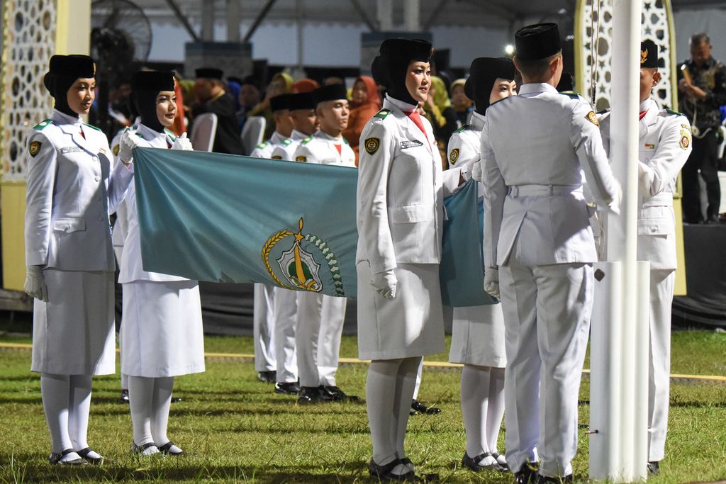 Anggota Pasukan Pengibar Bendera mengibarkan bendera Musabaqah Tilawatil Quran (MTQ) saat pembukaan MTQ Nasional XXX Tahun 2024 di Stadion Gelora Kadrie Oening, Samarinda, Kalimantan Timur, Minggu (8/9/2024).