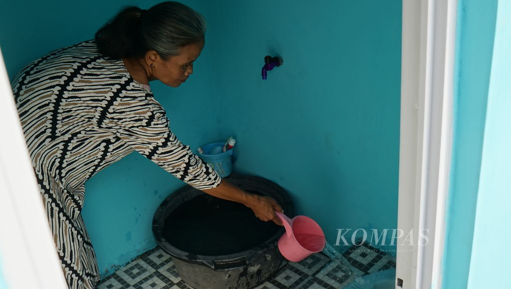 Warga penerima manfaat jamban sehat keluarga menyiram air pada kamar mandi miliknya, di Kelurahan Mojo, Kecamatan Pasar Kliwon, Kota Surakarta, Jawa Tengah, Kamis (16/3/2023). Jamban sehat tersebut dibangun dari donasi pembaca harian <i>Kompas</i> yang dikelola oleh Yayasan Dana Kemanusiaan Kompas.