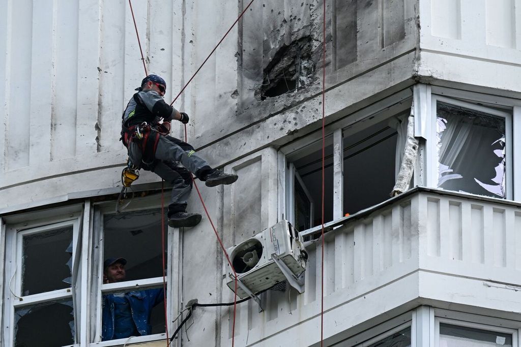 An specialist officer examines the wall of an apartment that was torn due to an unmanned aerial vehicle attack in Moscow, Russia, on Tuesday (30/5/2023).
