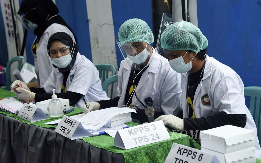 Petugas KPPS menggunakan pakaian medis saat bertugas dalam Pilkada Kota Surabaya di TPS 24 yang bertema tenaga medis Covid-19 di Kelurahan Menur Pumpungan, Kecamatan Sukolilo, Surabaya, Jawa Timur, 9 Desember 2020. 