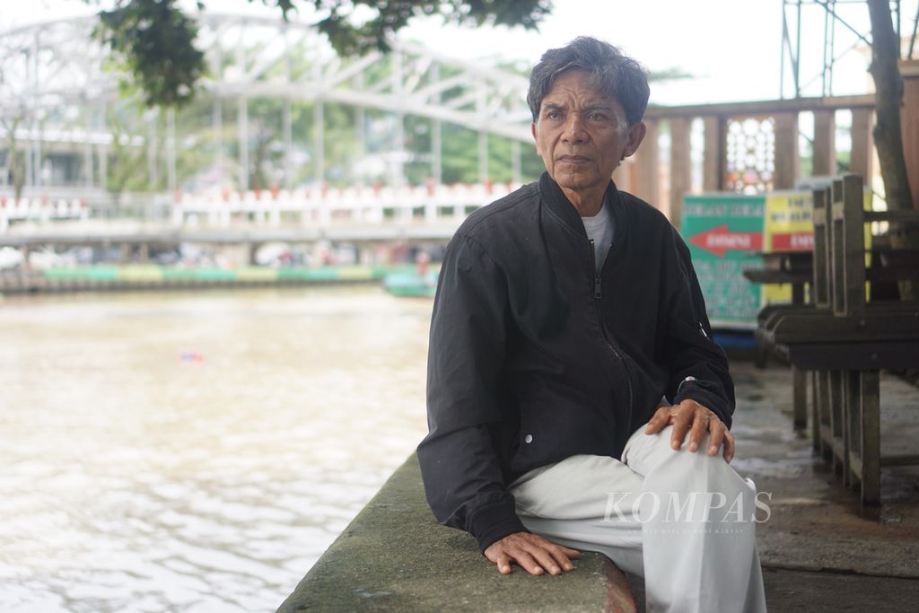 Misman (64), peraih Kalpataru tingkat nasional 2023, duduk di tepi Sungai Karang Mumus, Samarinda, Kalimantan Timur, Jumat (21/7/2023).