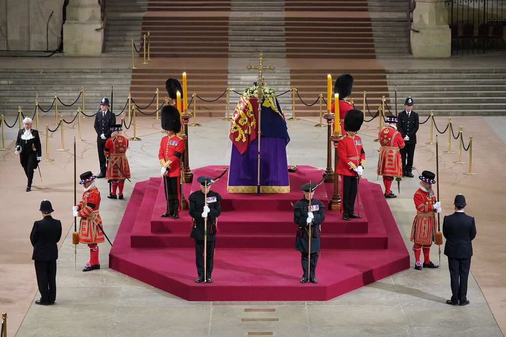 Peti jenazah Ratu Elizabeth II yang terbungkus bendera Royal Standard berada di Westminster Hall, di Istana Westminster, London, saat penghormatan terhadap jenazah Ratu dalam persemayaman resmi kenegaraan (official lying-in-state) diakhiri setelah empat hari dibuka untuk publik, Senin (19/9/2022).  (Yui Mok/Pool Photo via AP)