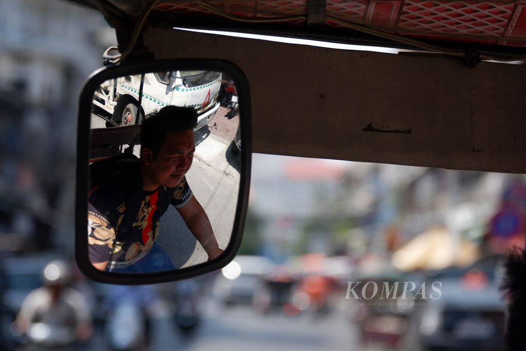 Seorang pengemudi mengendarai tuktuk di dalam Kota Phnom Penh, Selasa (2/5/2023) siang. Tuktuk menjadi andalan bagi para turis asing  bepergian ke beberapa tempat di Phnom Penh