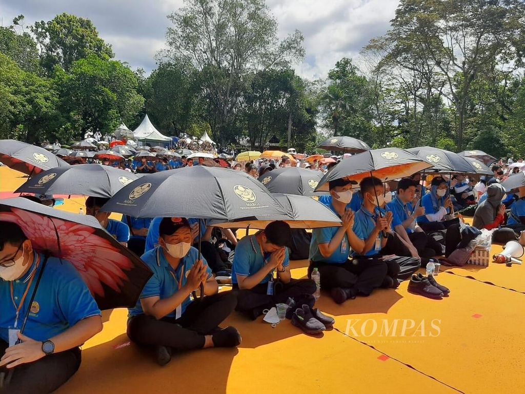 Di tengah teriknya sinar matahari, banyak umat Buddha mengikuti rangkaian perayaan Waisak dengan berteduh di bawah payung, seperti terlihat pada Senin (16/5/2022).