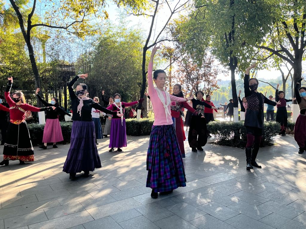 Sekelompok perempuan yang sebagian berusia lanjut sedang latihan menari bersama di Taman Danau Hijau, Kunming, Provinsi Yunnan, China, Minggu (20/11/2022) pagi. Banyak orang tua di China yang senang menghabiskan waktu berkegiatan bersama di taman-taman.