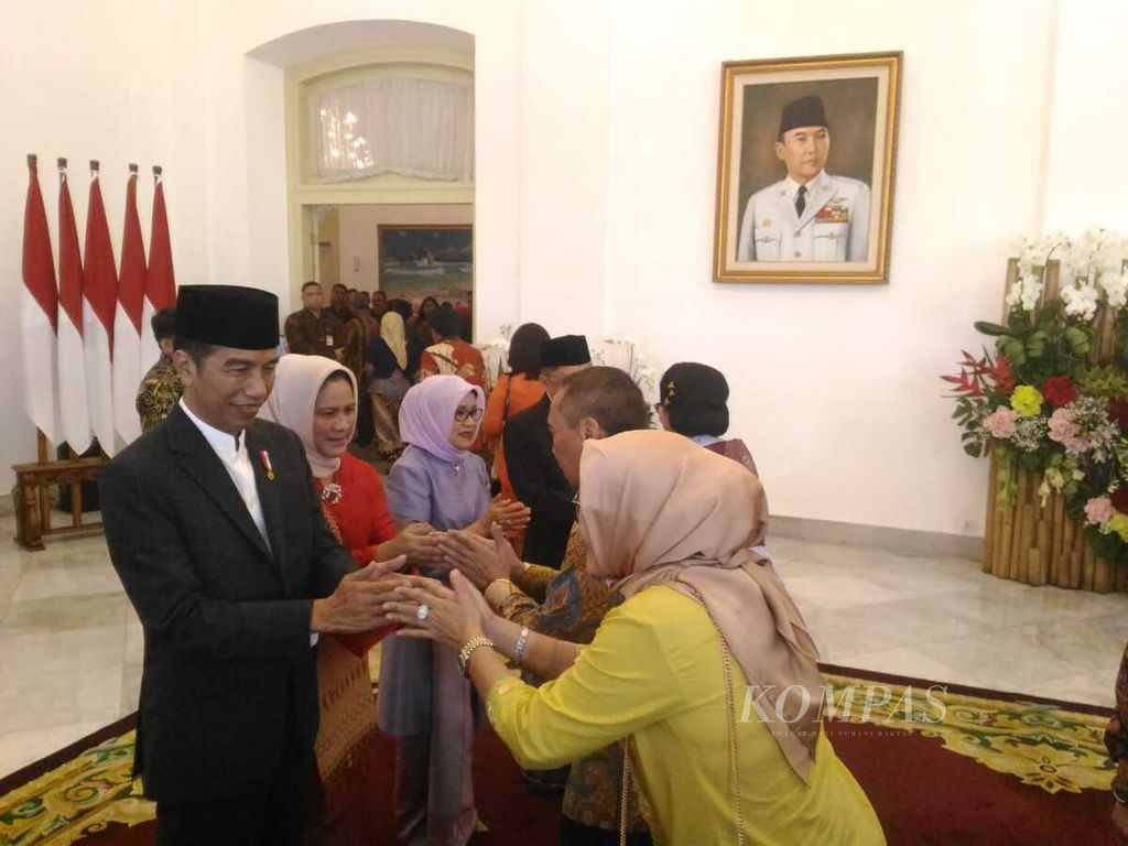 Presiden Joko Widodo, didampingi Ny Iriana, sedang menerima ucapan salam dari warga pada acara <i>open house</i> di Istana Negara, Jakarta. Kata <i>open house</i> bisa dipadankan dengan <i>buka pintu</i>.