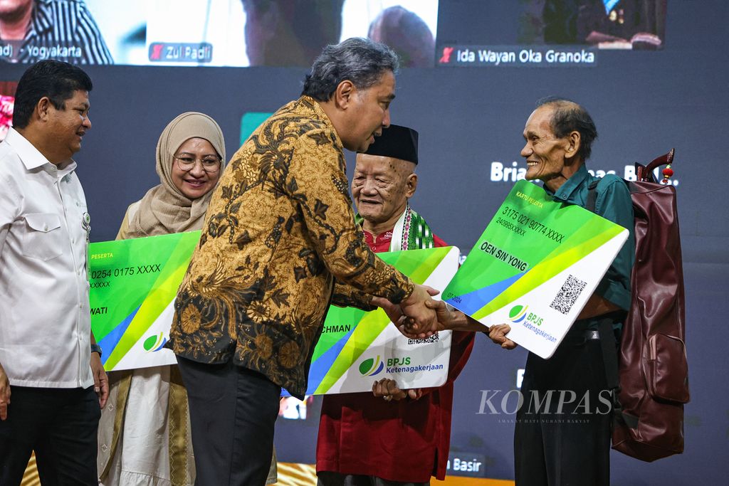 Direktur Jenderal Kebudayaan Kementerian Pendidikan, Kebudayaan, Riset, dan Teknologi Hilmar Farid (tengah), didampingi Direktur Kepesertaan BPJS Ketenagakerjaan Zainudin (kiri), menyerahkan kartu peserta BPJS Ketenagakerjaan secara simbolis kepada penerima Anugerah Kebudayaan Indonesia, yaitu Oen Sin Yong (kanan), Abdul Rachman (kedua dari kanan), serta Anitawati (kedua dari kiri), di Gedung Kemendikbudristek, Jakarta, Selasa (23/7/2024). 