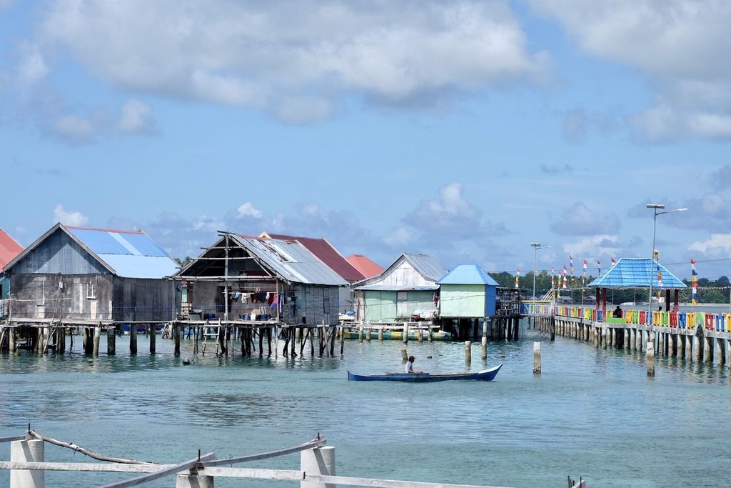 Warga menaiki perahu melintas di Kampung Mola, Wakatobi, Sulawesi Tenggara, Rabu (8/6/2022). Sebanyak 525 sertifikat tanah akan dibagikan pemerintah ke warga Kampung Mola di pesisir Wakatobi. Sebagian besar mereka tinggal di rumah semipermanen yang dibangun di atas laut.