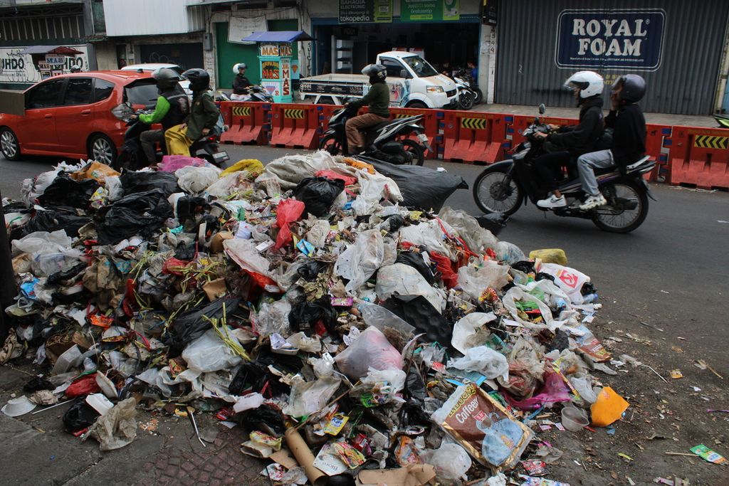 Sejumlah pengendara melewati tumpukan sampah di sisi Jalan Ahmad Yani dekat Pasar Cicadas, Kota Bandung, Jawa Barat, Minggu (5/11/2023).