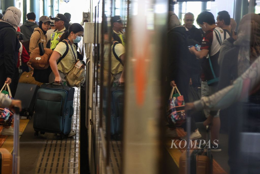 Penumpang membawa koper saat masuk ke kereta di Stasiun Gambir, Jakarta, Kamis (21/12/2023). Lebih dari 14.000 warga meninggalkan Jakarta melalui Stasiun Gambir pada 21 Desember 2023. 