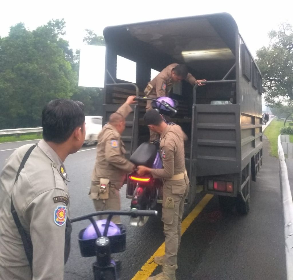Petugas Satuan Polisi Pamong Praja Kota Bogor, Jawa Barat, mengangkut sepeda istrik sewa yang ditelantarkan oleh peyewa di jalan raya di Baranangsiang, Selasa (20/12/2022).