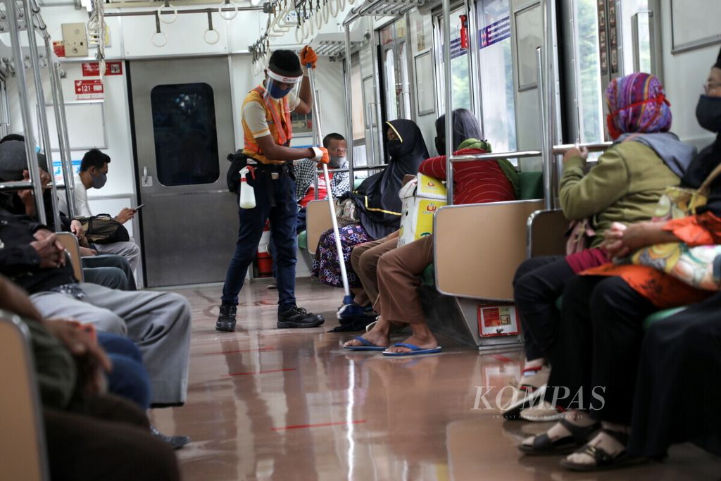 Petugas kebersihan mengenakan pelindung wajah saat mengepel gerbong KRL Commuterline dalam perjalan dari Stasiun Rawa Buntu, Tangerang Selatan, Banten, menuju Stasiun Tanah Abang, Jakarta, Selasa (9/6/2020). 