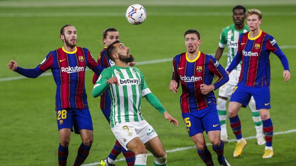 Pemain Real Betis, Borja Iglesias (depan) berusaha mengontrol bola diantara kepungan pemain Barcelona. 