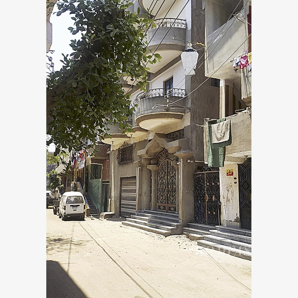 Kondisi jalan di depan rumah Mo Salah di Nagrig, 130 kilometer di utara Kairo, Mesir. Rumah Salah tampak memiliki balkon dan dinding di lantai dua bercat putih. Di jalan tersebut dulu Salah kecil bermain sepak bola.
