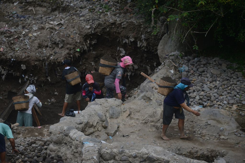 Buruh perempuan menggendong pasir dan batu yang ditambang di Sungai Grawah, Desa Gubug, Cepogo, Boyolali, Jawa Tengah, Senin (13/7/2020). 